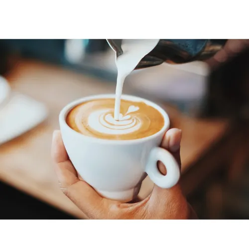 یک فنجان شیر قهوه دردست فردی برای دیزاین